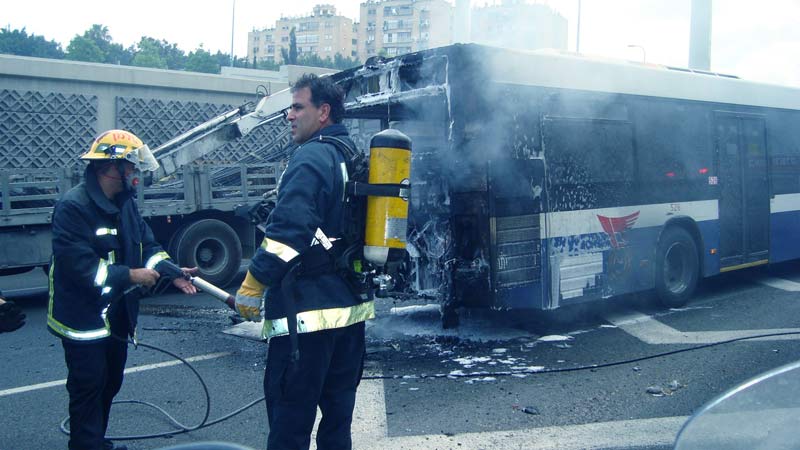 אוטובוס עולה באש ולידו כבאים