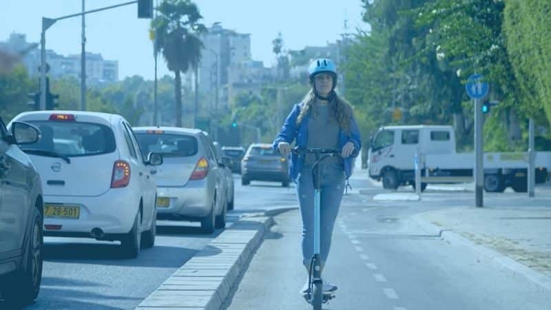 בחורה רוכבת על קורקינט